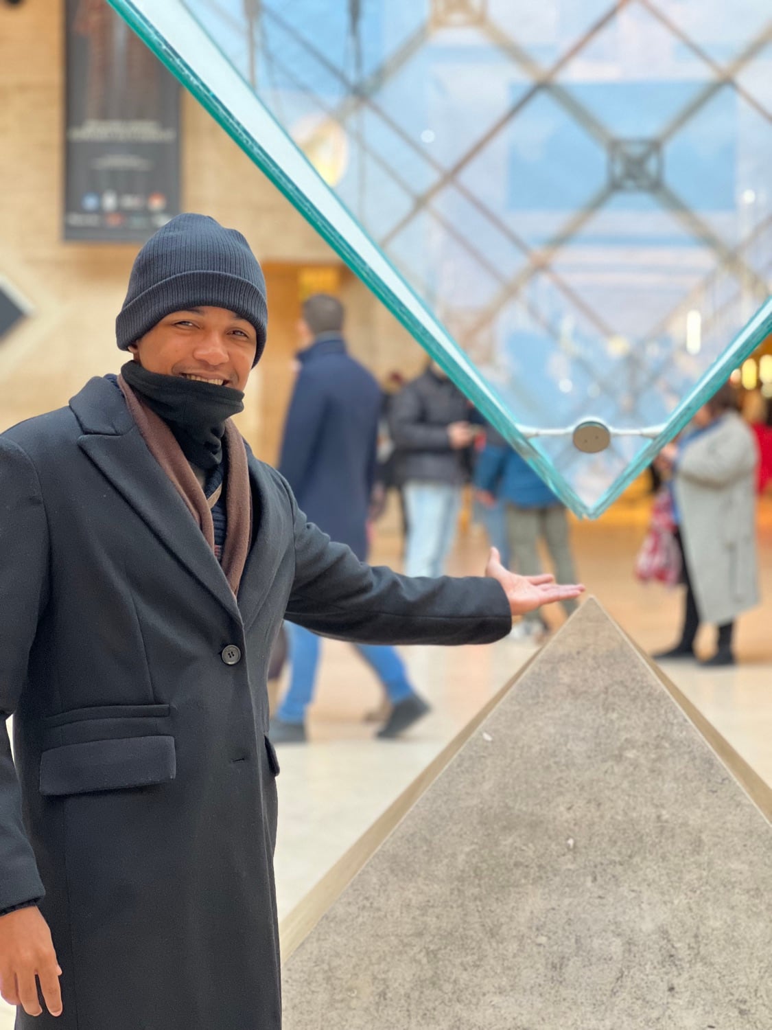 Thiago próximo à pirâmide do Louvre, em Paris